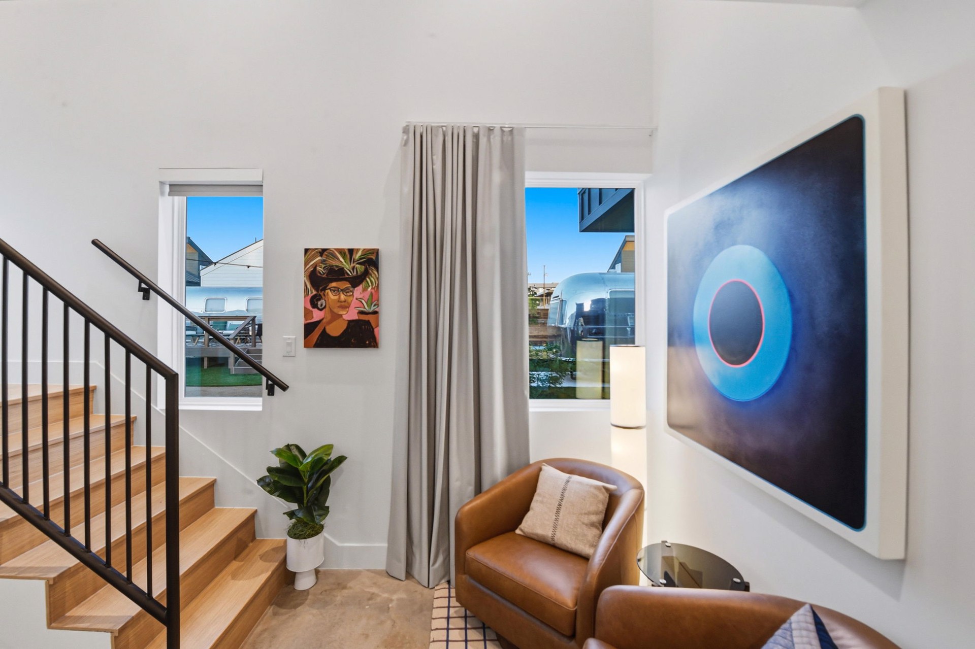 A luminous blue abstract painting beside leather seating in a SOMA casita
