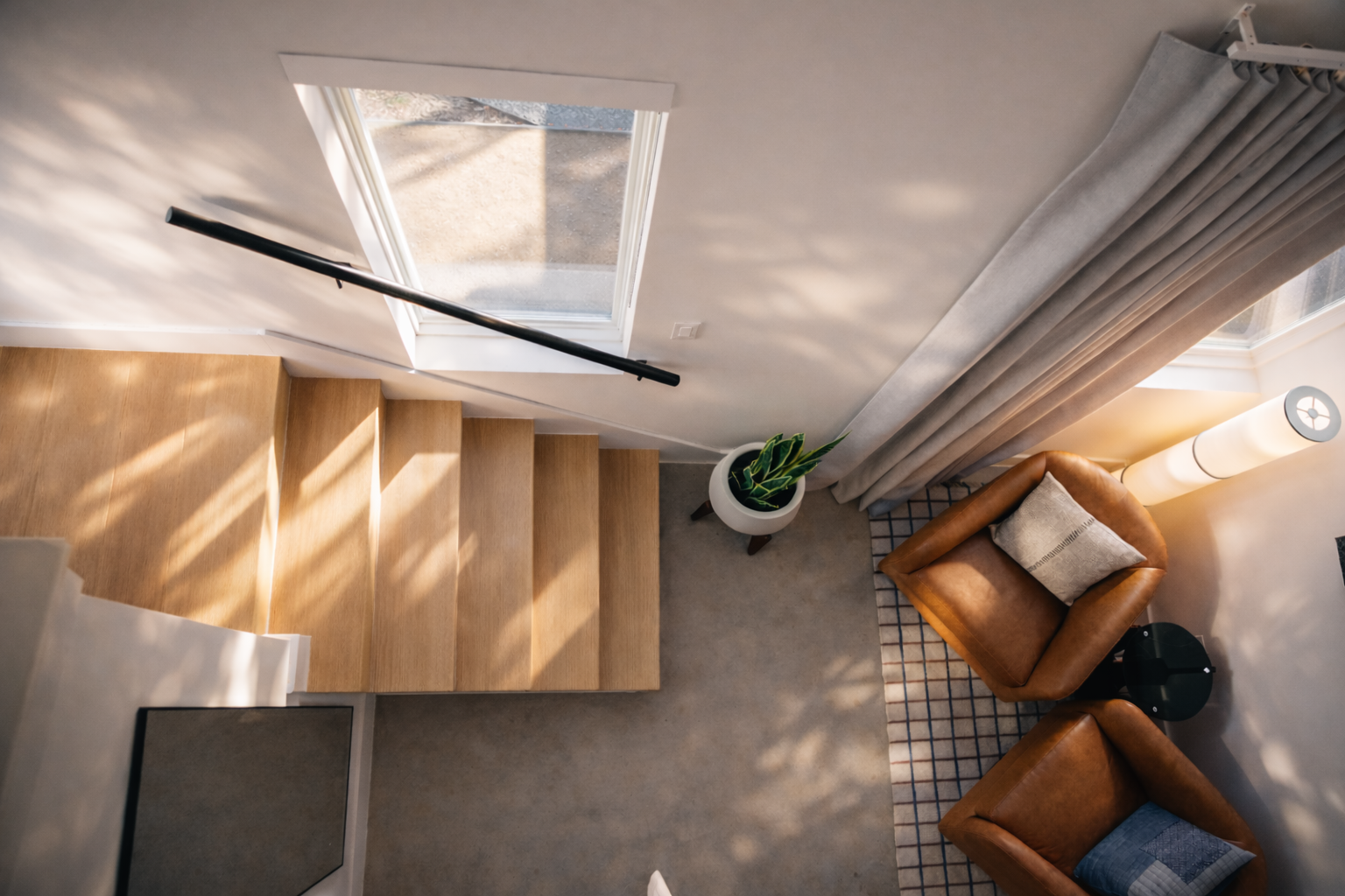 Two-story casita loft with wood stairs and leather chairs