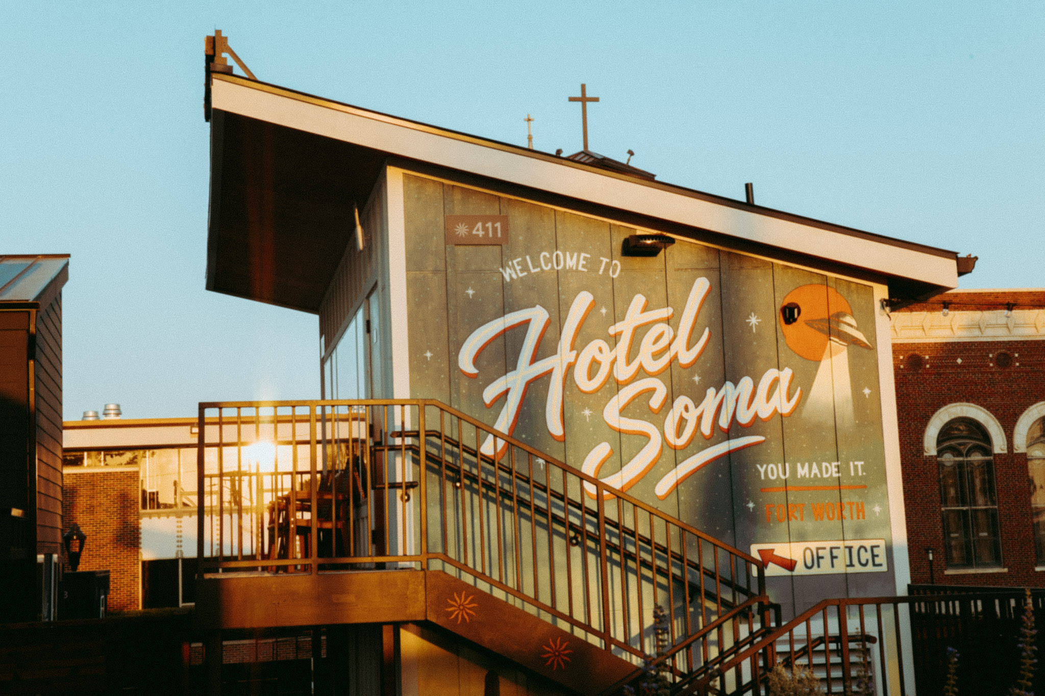 The hand-painted Welcome to Hotel SOMA mural above the office stairs in Fort Worth