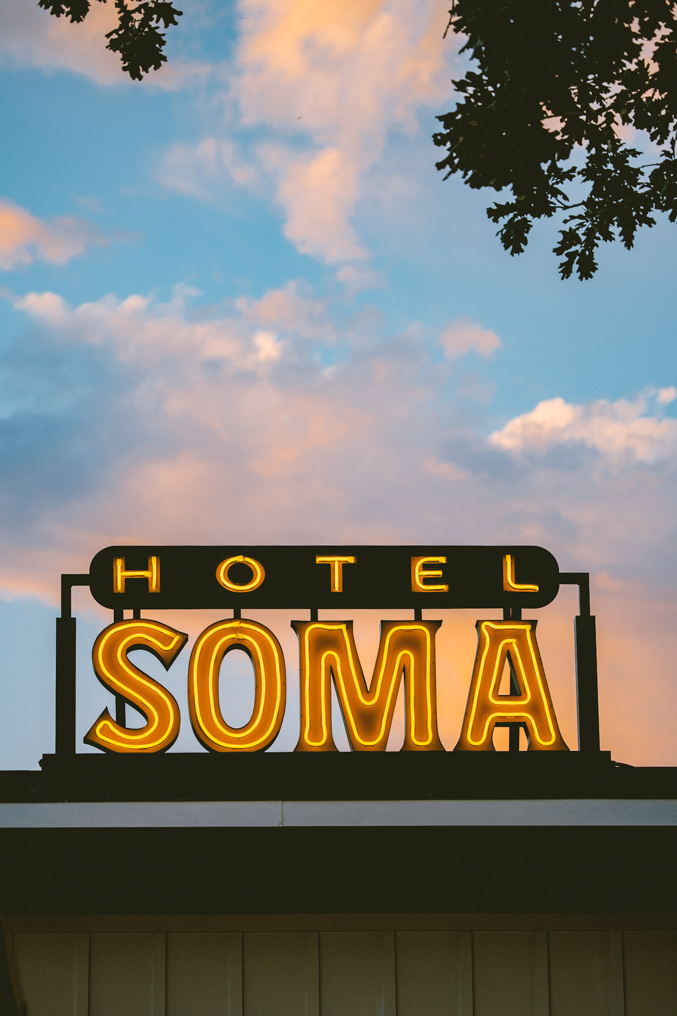 The Hotel SOMA neon sign glowing against a Fort Worth sunset